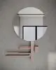 Spiegel mit runder Form und minimalistischem Design, kombiniert mit Ablage und Halterung, montiert an einer grauen Wand, von Ideal Standard.